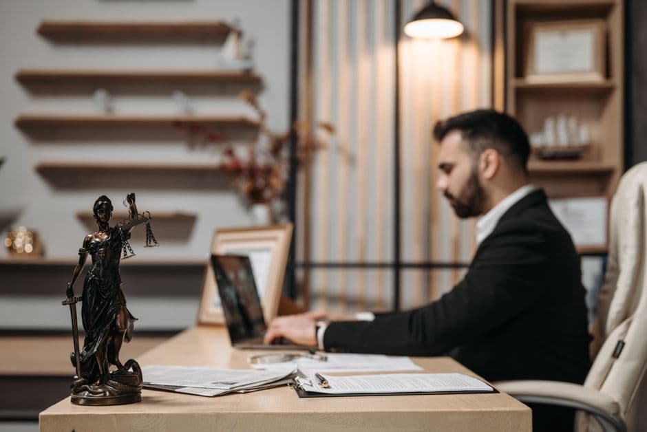 An IP advocate working at a desk beside a statue of Lady Justice